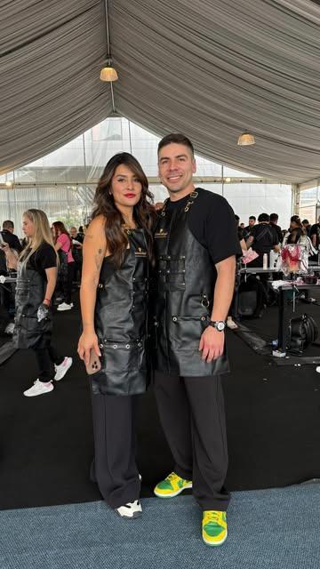 Dany Mora y su compañera con delantales de cuero en un evento de peluquería