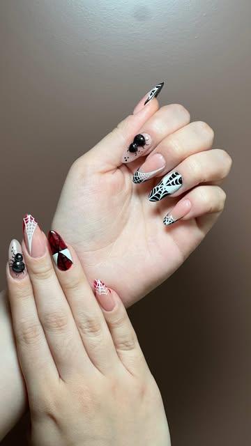 Uñas almendradas con arte en blanco, negro y rojo